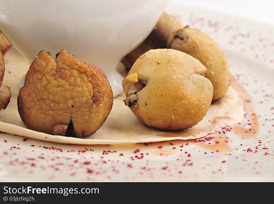 Mushrooms in hot fan with sauce on a white plate