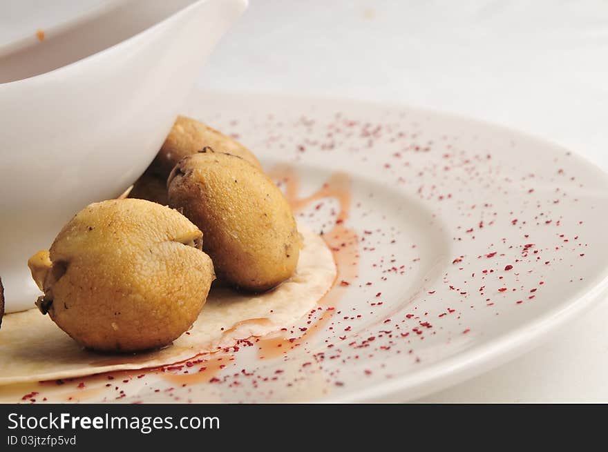 Mushrooms in hot fan with sauce on a white plate