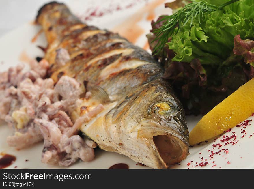 The fried fish with sauce and salad on a white plate