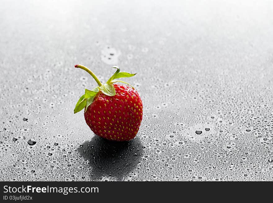 Red strawberry with water drops over black