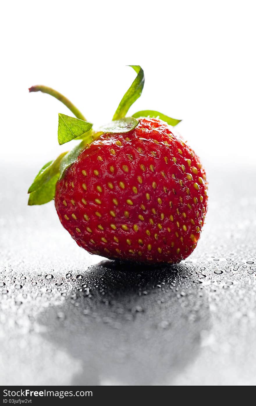 Red strawberry with water drops over black