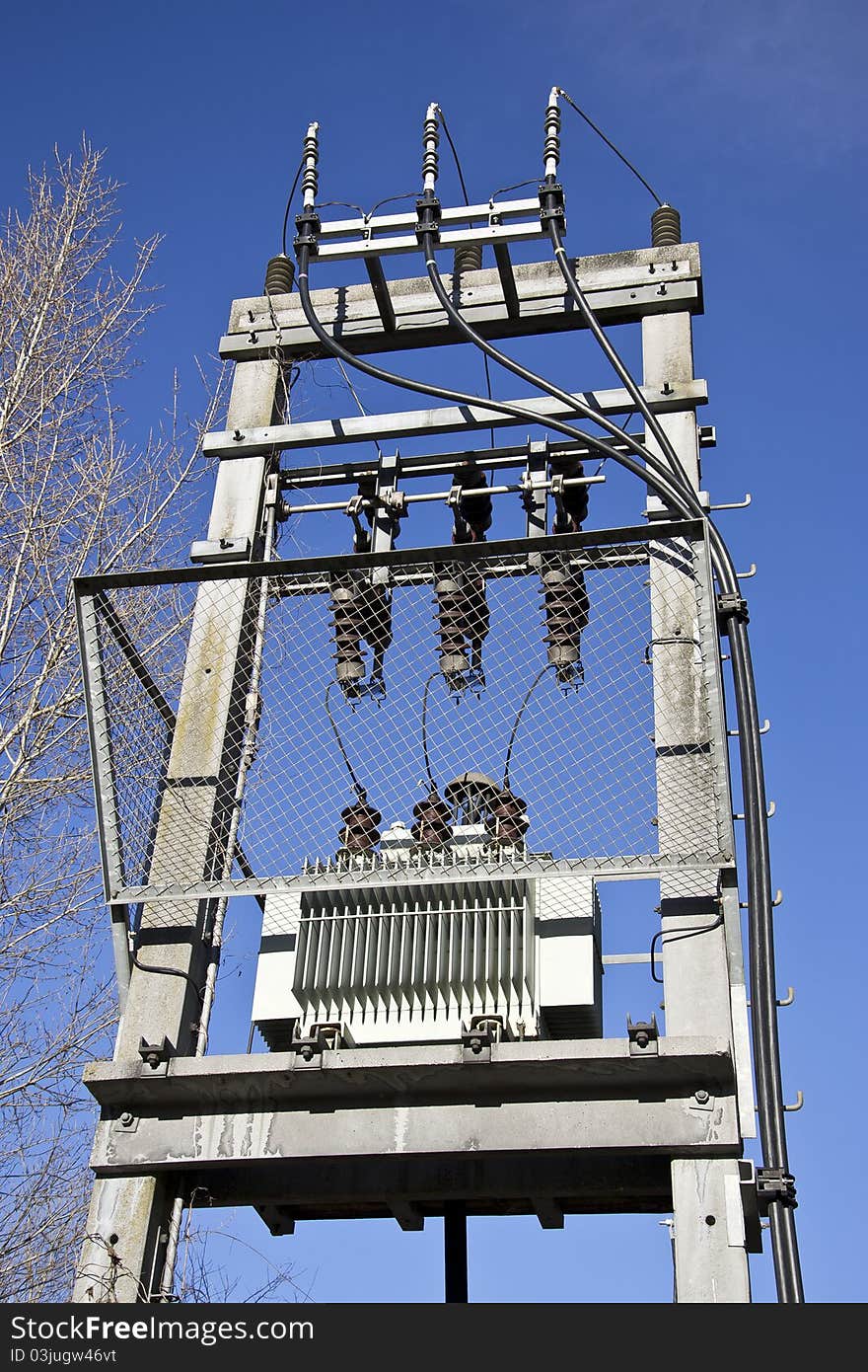 An electric tower next to a tree. An electric tower next to a tree.