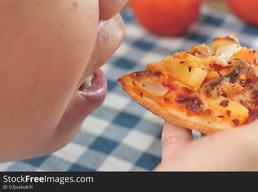 Hand taking freshly baked pizza close to mouth. Hand taking freshly baked pizza close to mouth.