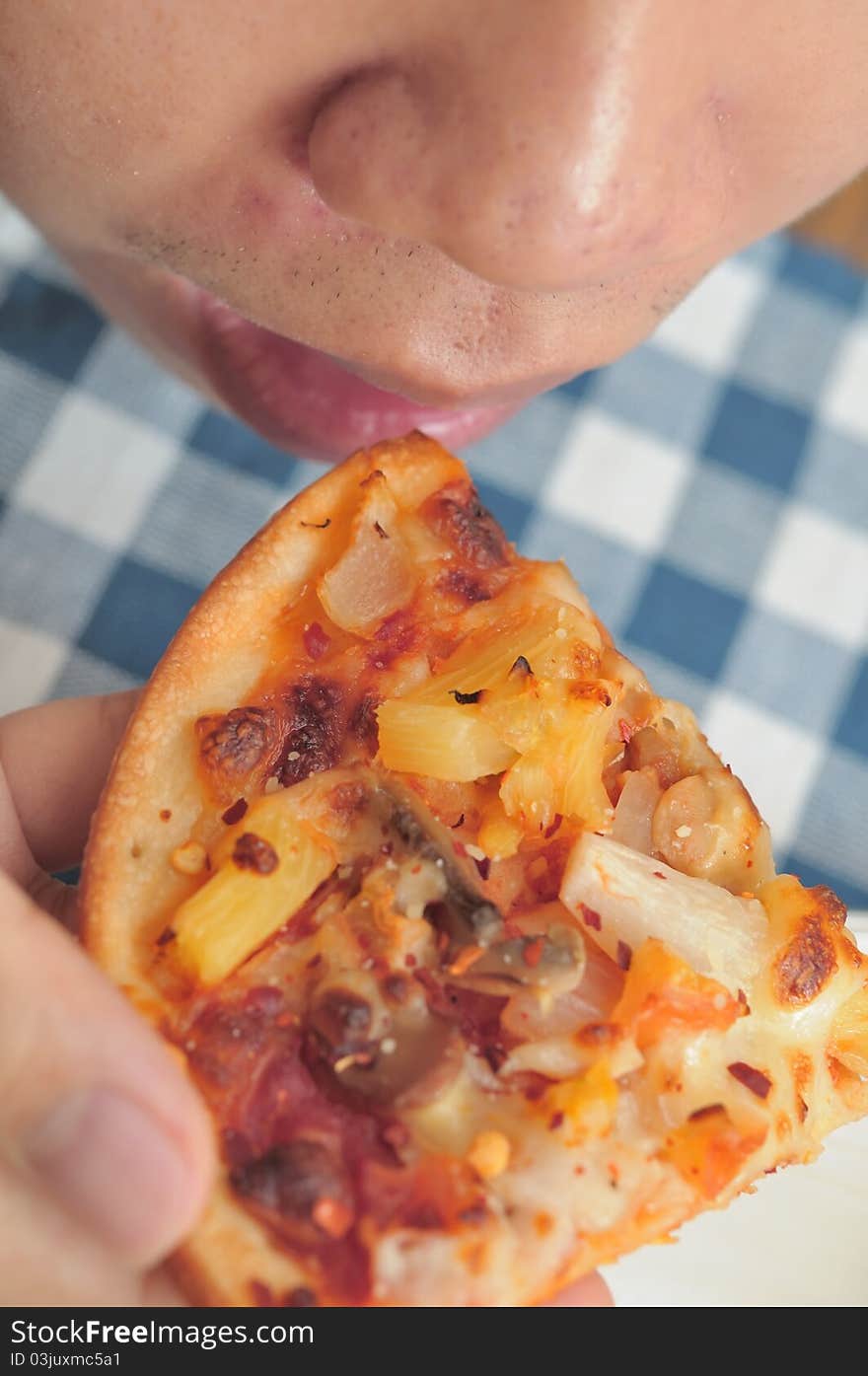 Top down view of Asian man eating pizza. Top down view of Asian man eating pizza.