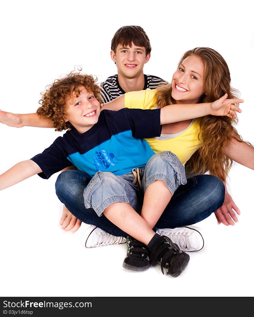 Mother and children sitting on floor isolated over the white background. Mother and children sitting on floor isolated over the white background.