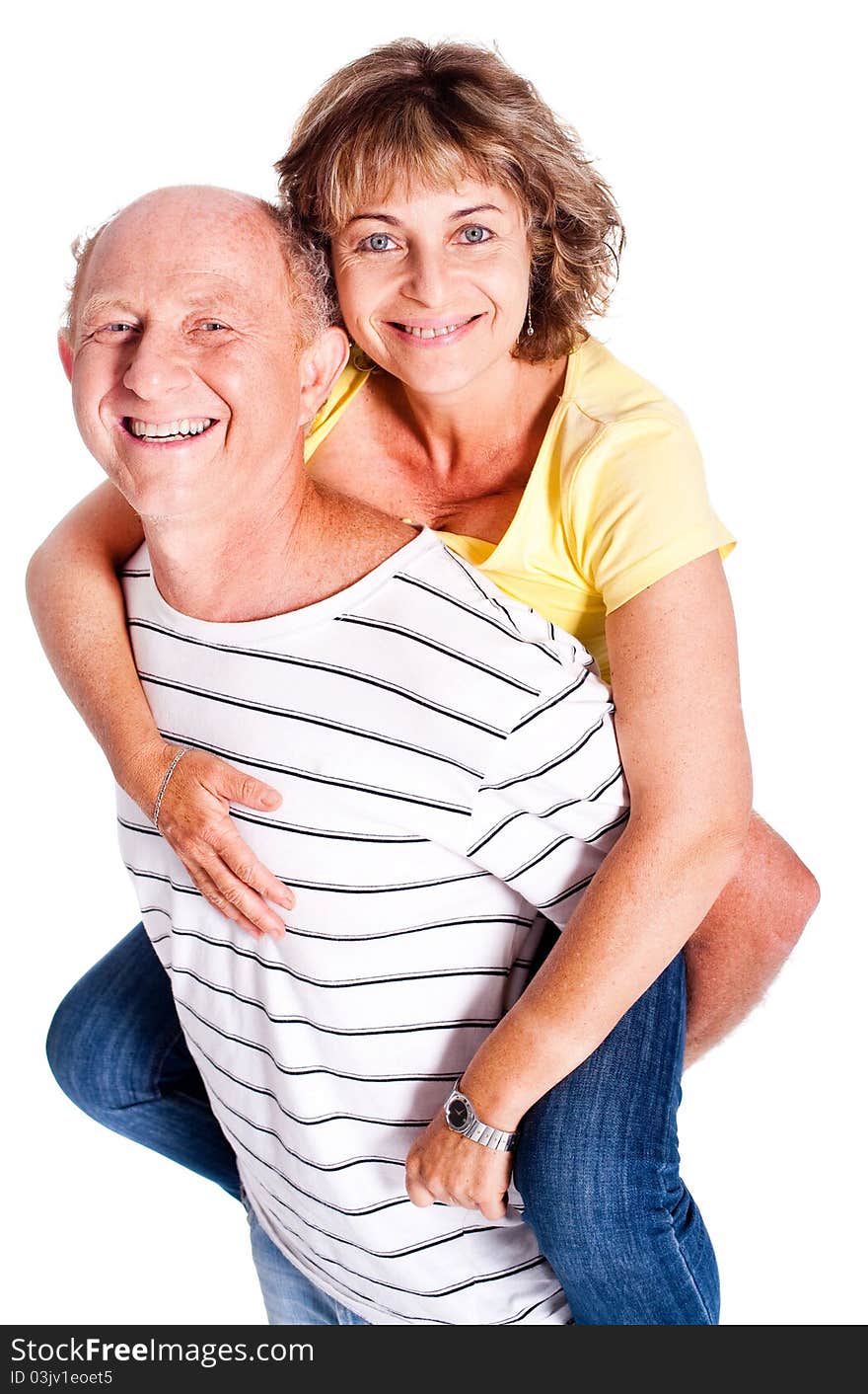 Senior man giving woman piggyback ride, indoors..