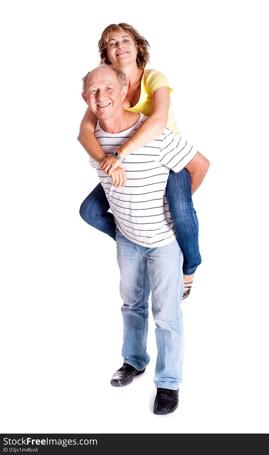 Senior man giving woman piggyback ride, indoors..