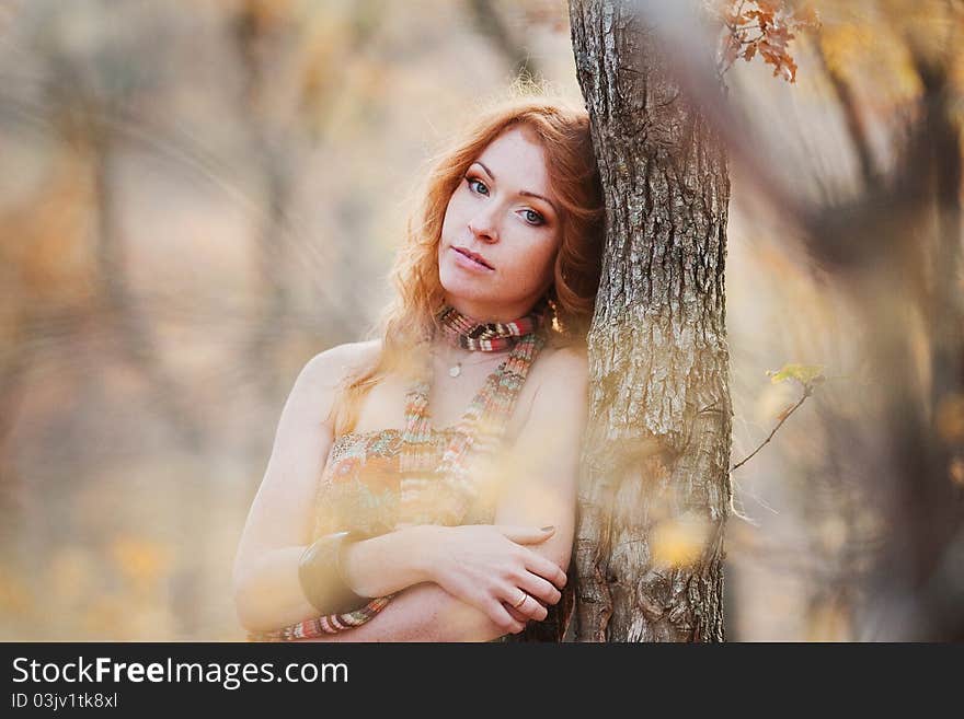 The red-haired girl in autumn leaves outdoor shot