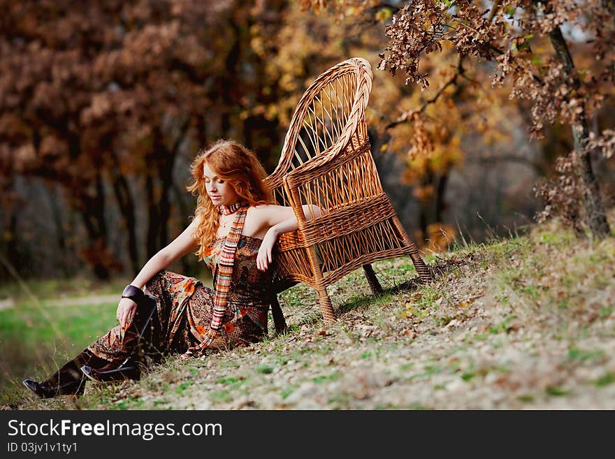 The red-haired girl in autumn leaves outdoor shot