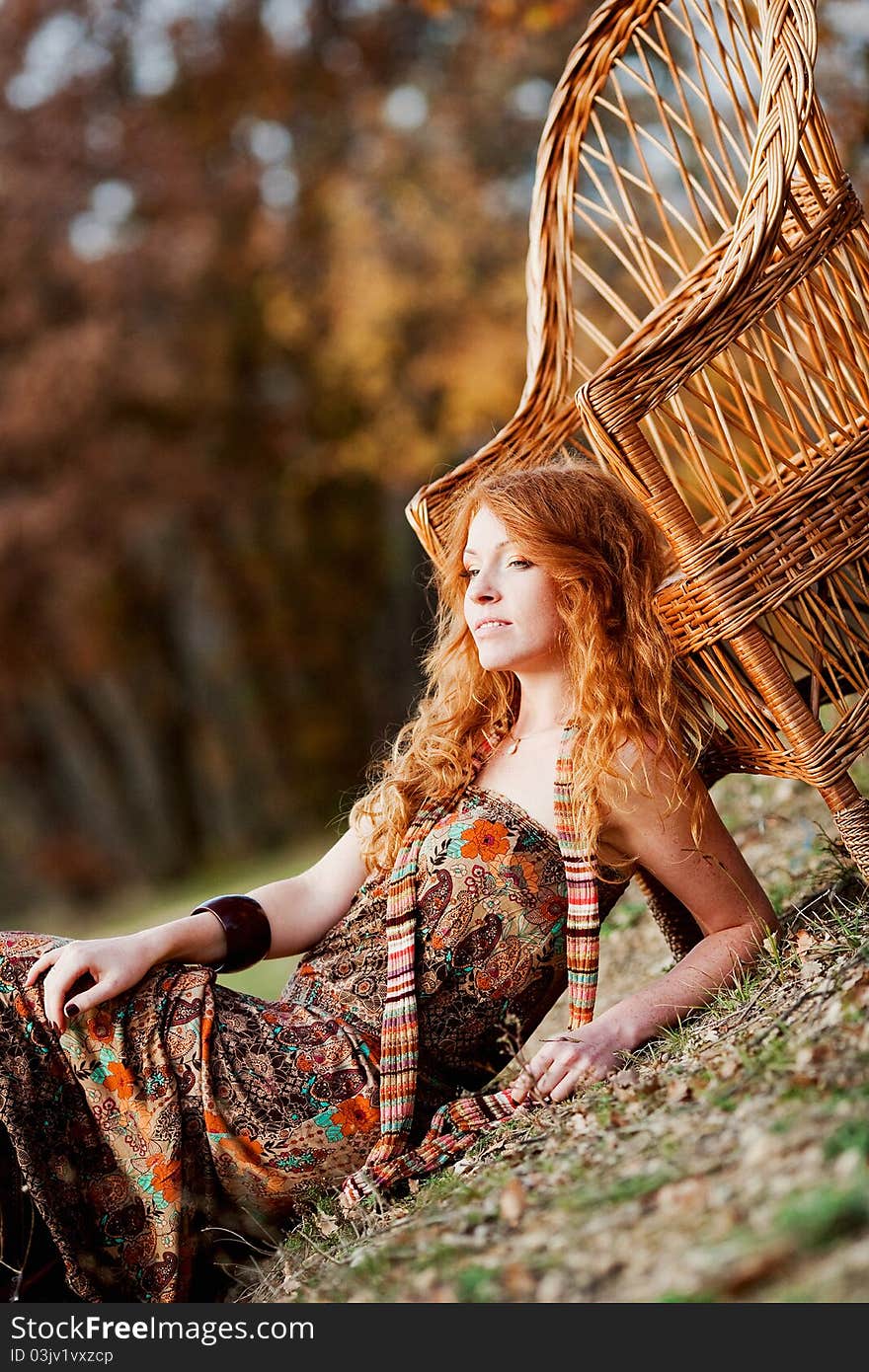 The red-haired girl in autumn leaves outdoor shot