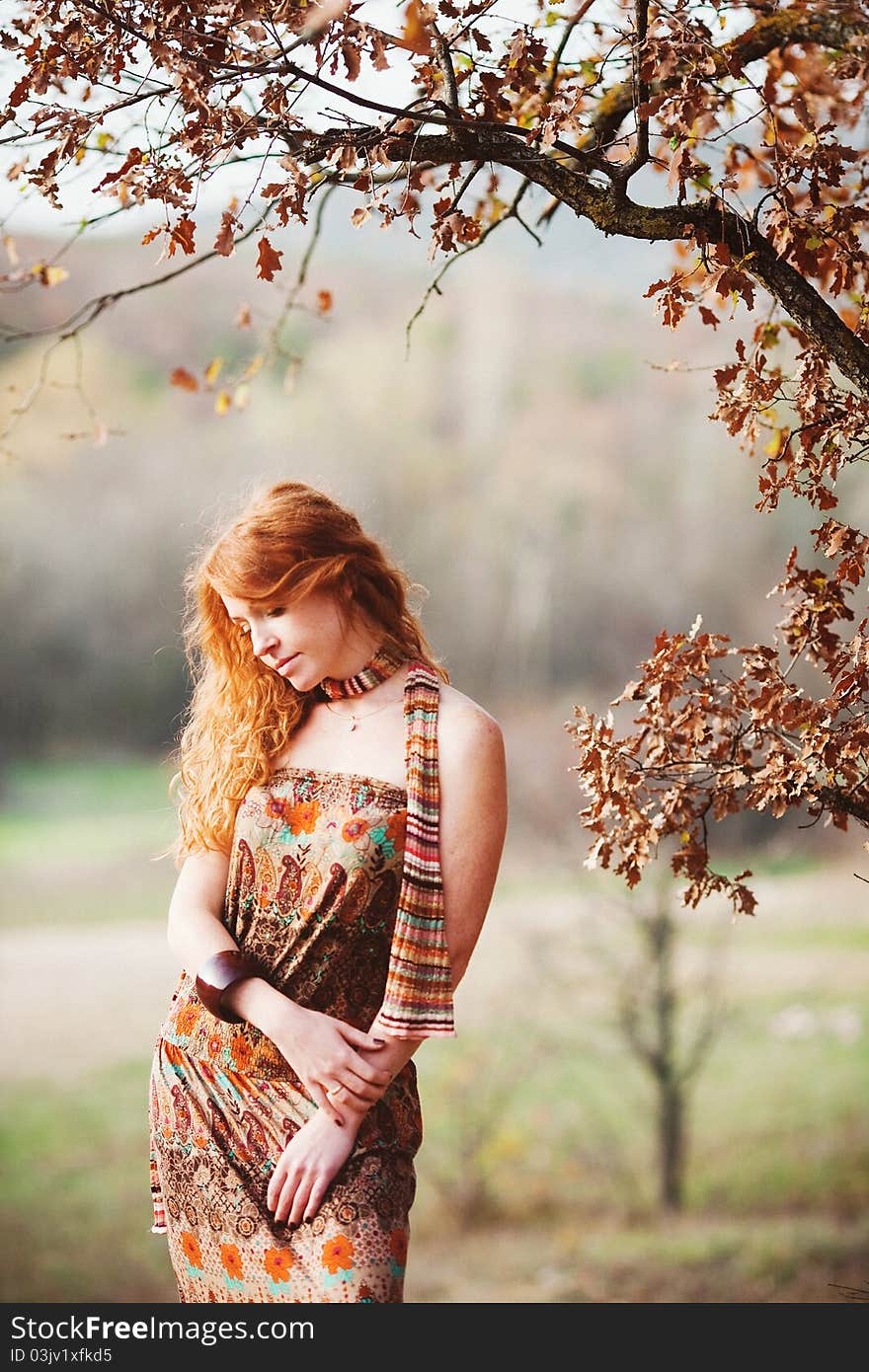 The red-haired girl in autumn leaves