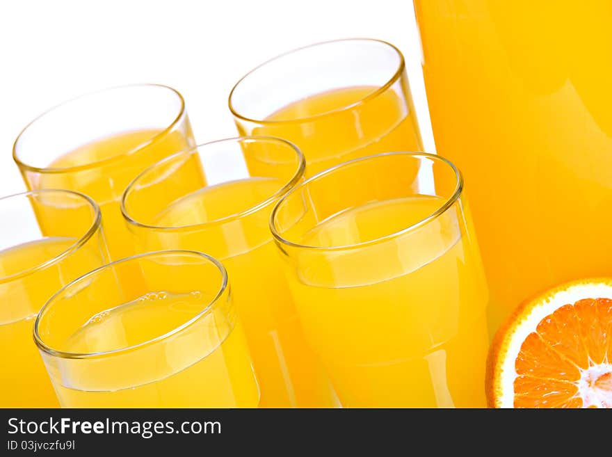 Pitcher and glasses full of juice, isolated on white; closeup