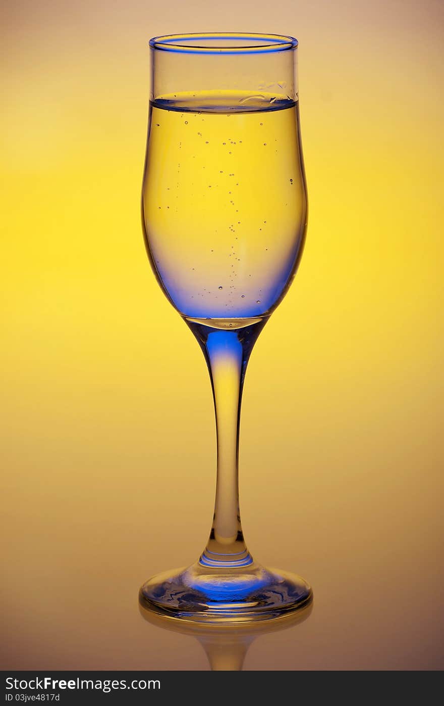 Glass with mineral water isolated on a yellow background