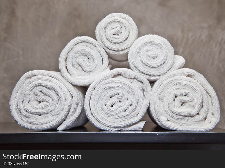 Bunch of white towels in bathroom shelf