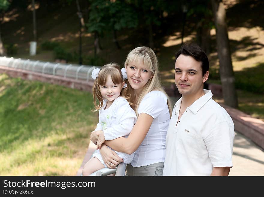 Family at park. Nice girl, mother and father