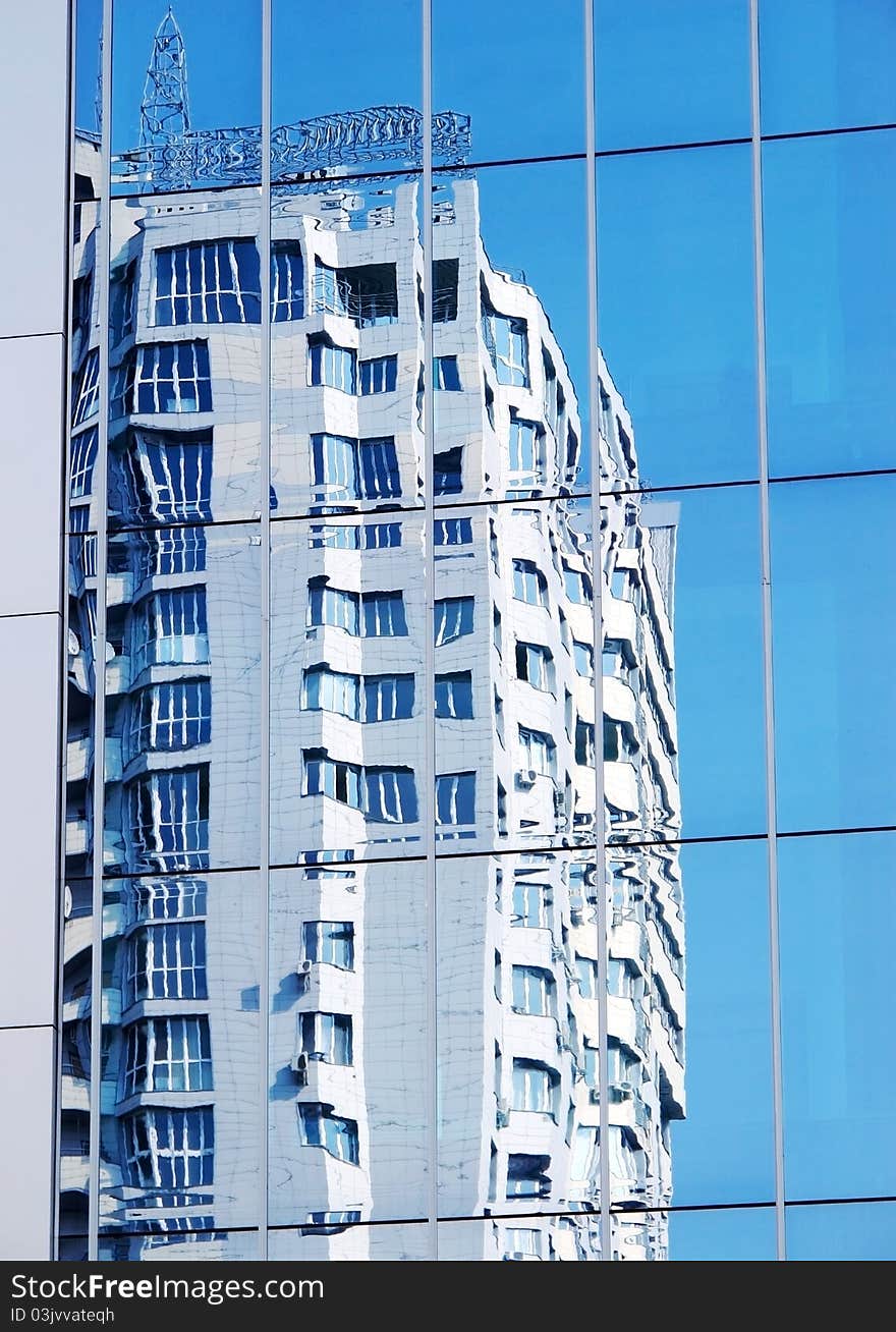 Apartment house in a city. Reflexion in a mirror wall. The blue sky. Apartment house in a city. Reflexion in a mirror wall. The blue sky.