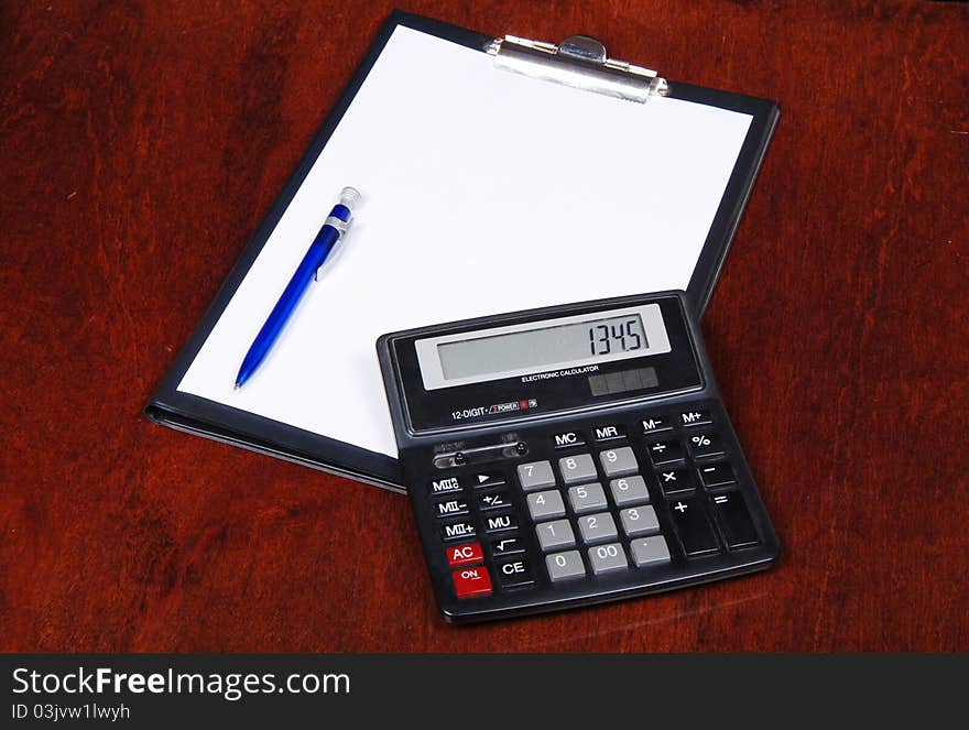 Calculator with notebook on table