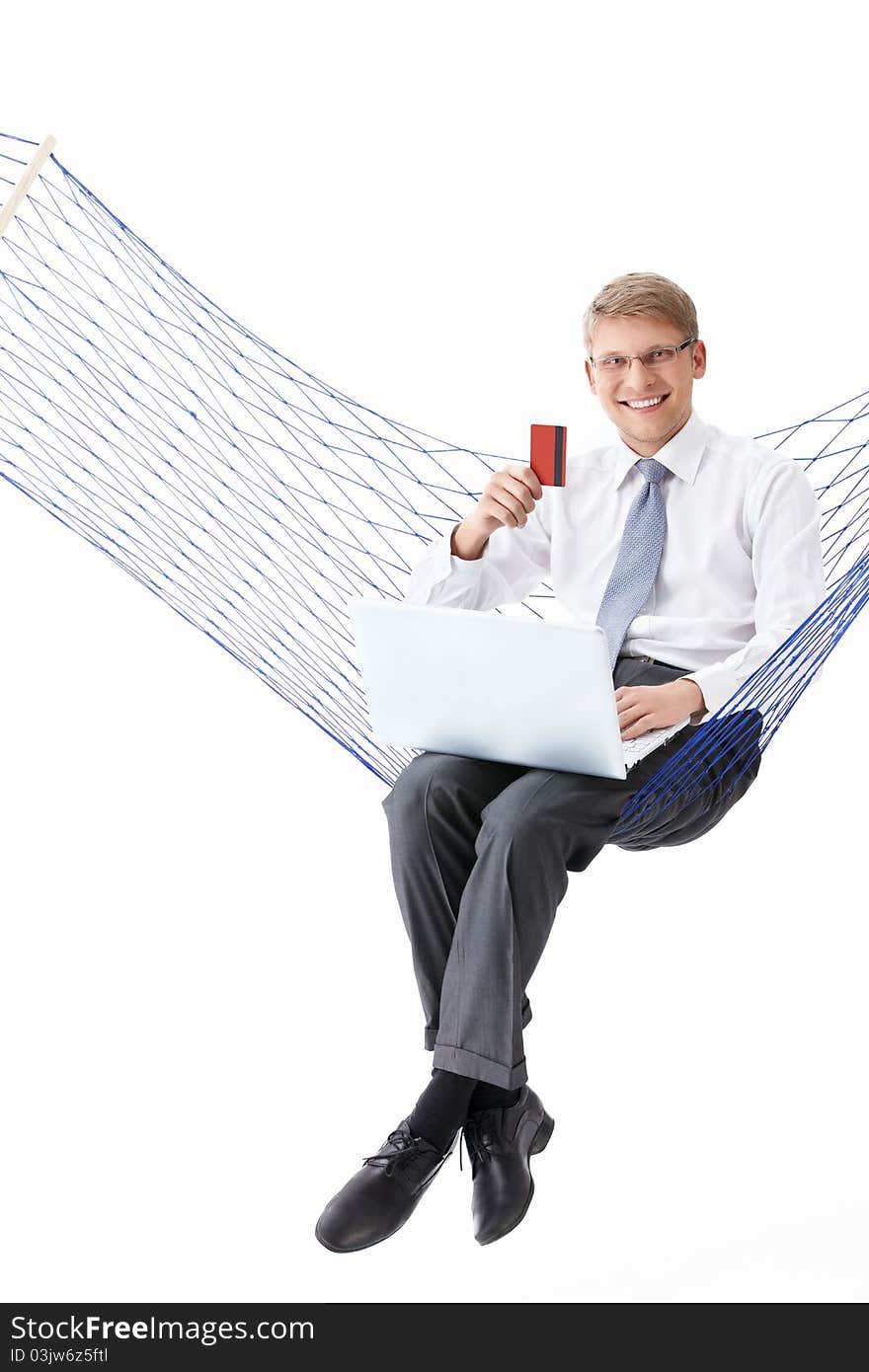 Businessman with laptop and credit card is isolated in a hammock