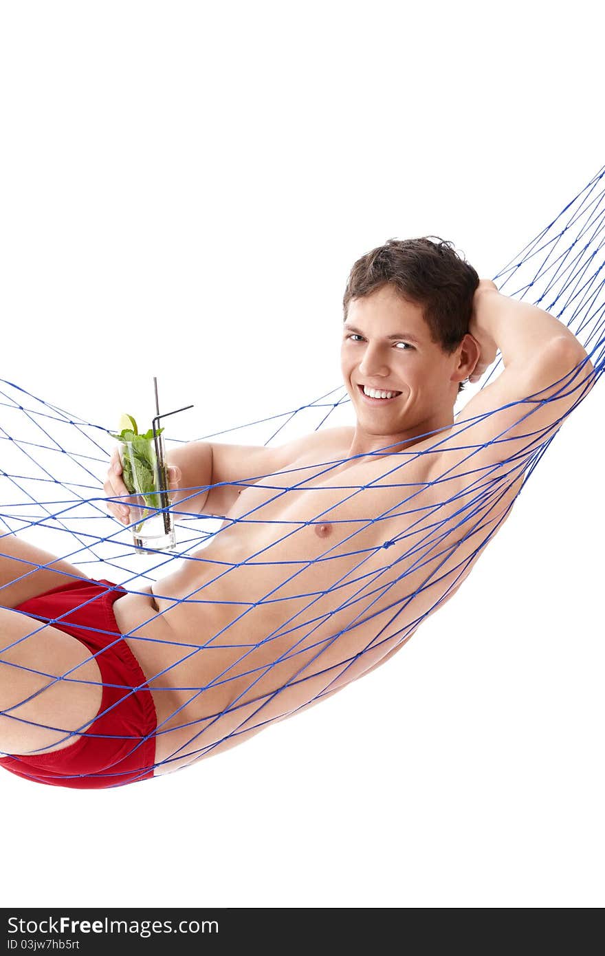 A young man with a cocktail in a hammock isolated. A young man with a cocktail in a hammock isolated