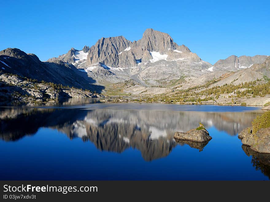 A majestic peak reflected in the calm morning water of Garnet Lake in the High Sierra. A majestic peak reflected in the calm morning water of Garnet Lake in the High Sierra