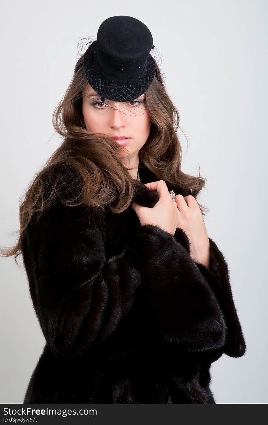 Close-up of beautiful young smiling woman in a fur coat and hat. Close-up of beautiful young smiling woman in a fur coat and hat