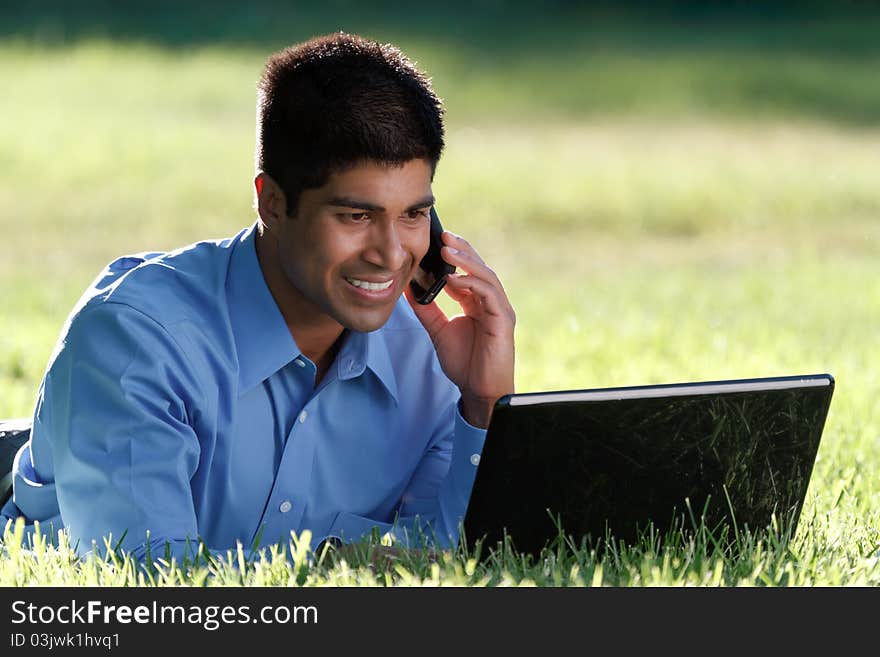 Happy young businessman working with at the park. Happy young businessman working with at the park