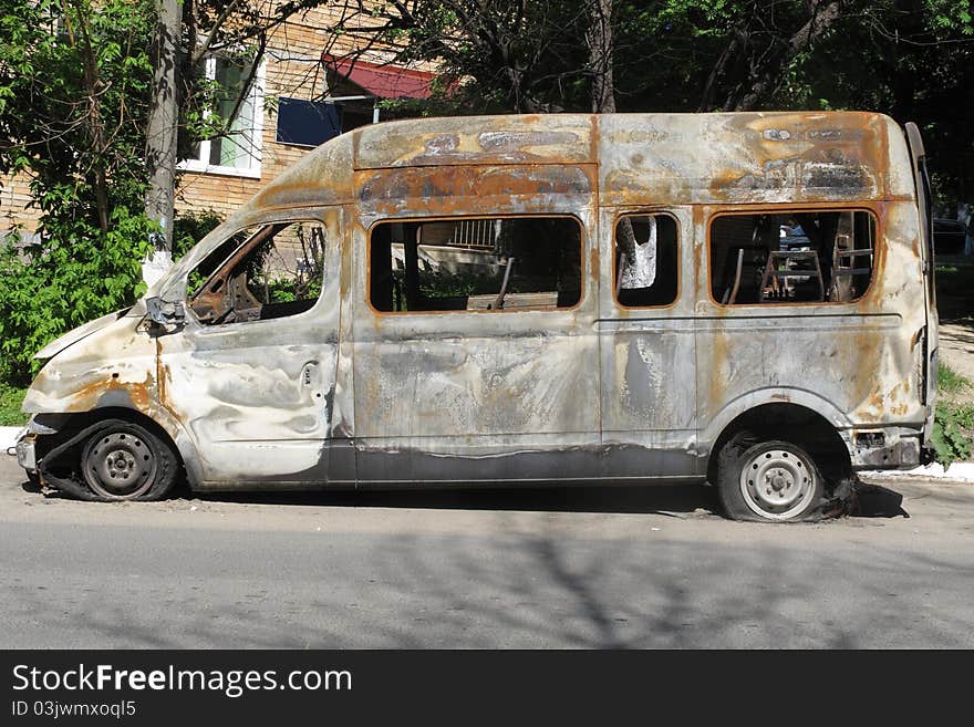 The image of burnt bus stands on the street