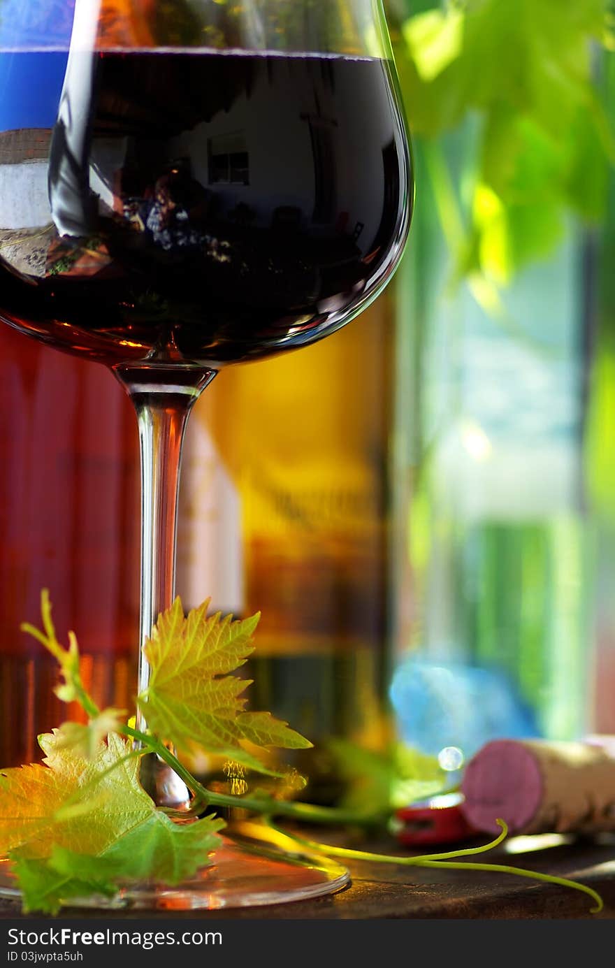 Bottle of red wine with glass and leaves. Bottle of red wine with glass and leaves.