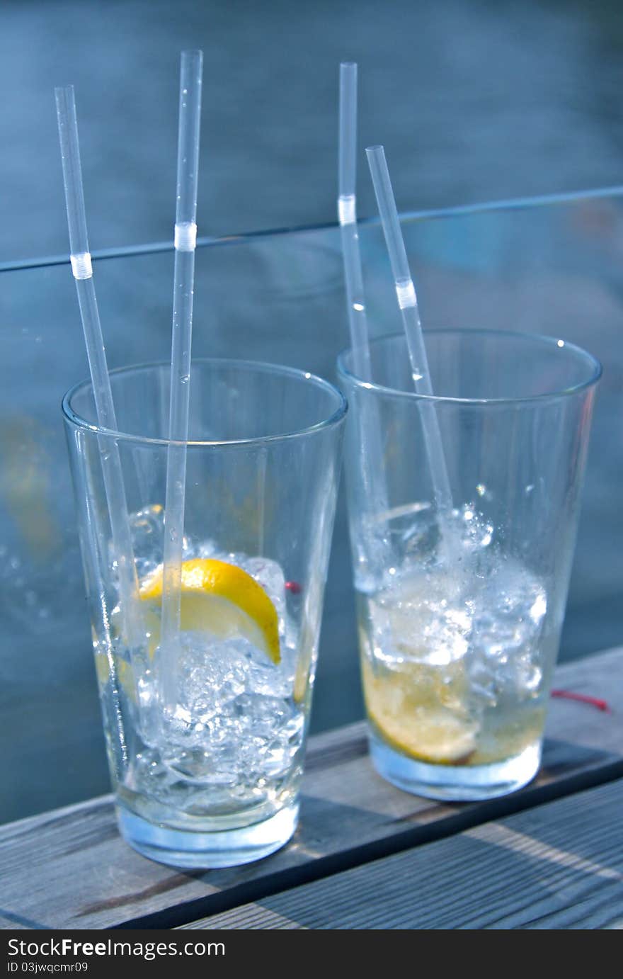 Two cocktails with ice and lemon for two people in love