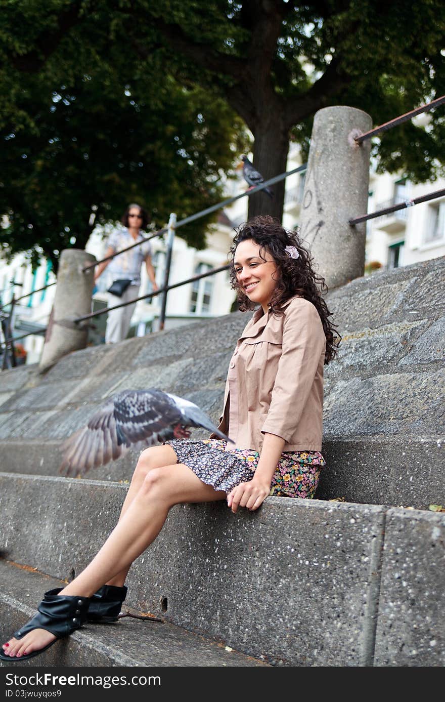 Smiling Latina Looking At Pigeon