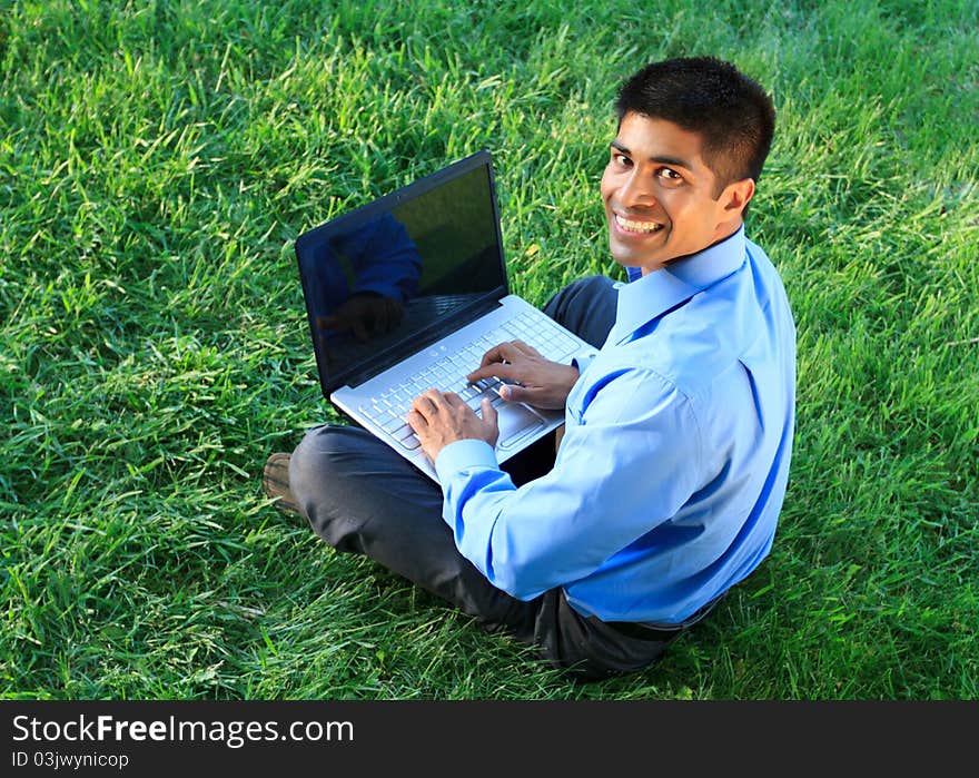 Young businessman working with laptop at the park. Young businessman working with laptop at the park