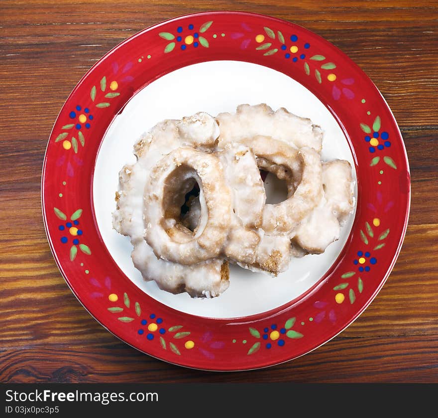 Glazed Cake Doughnuts on a painted plate and a wooden table. Glazed Cake Doughnuts on a painted plate and a wooden table