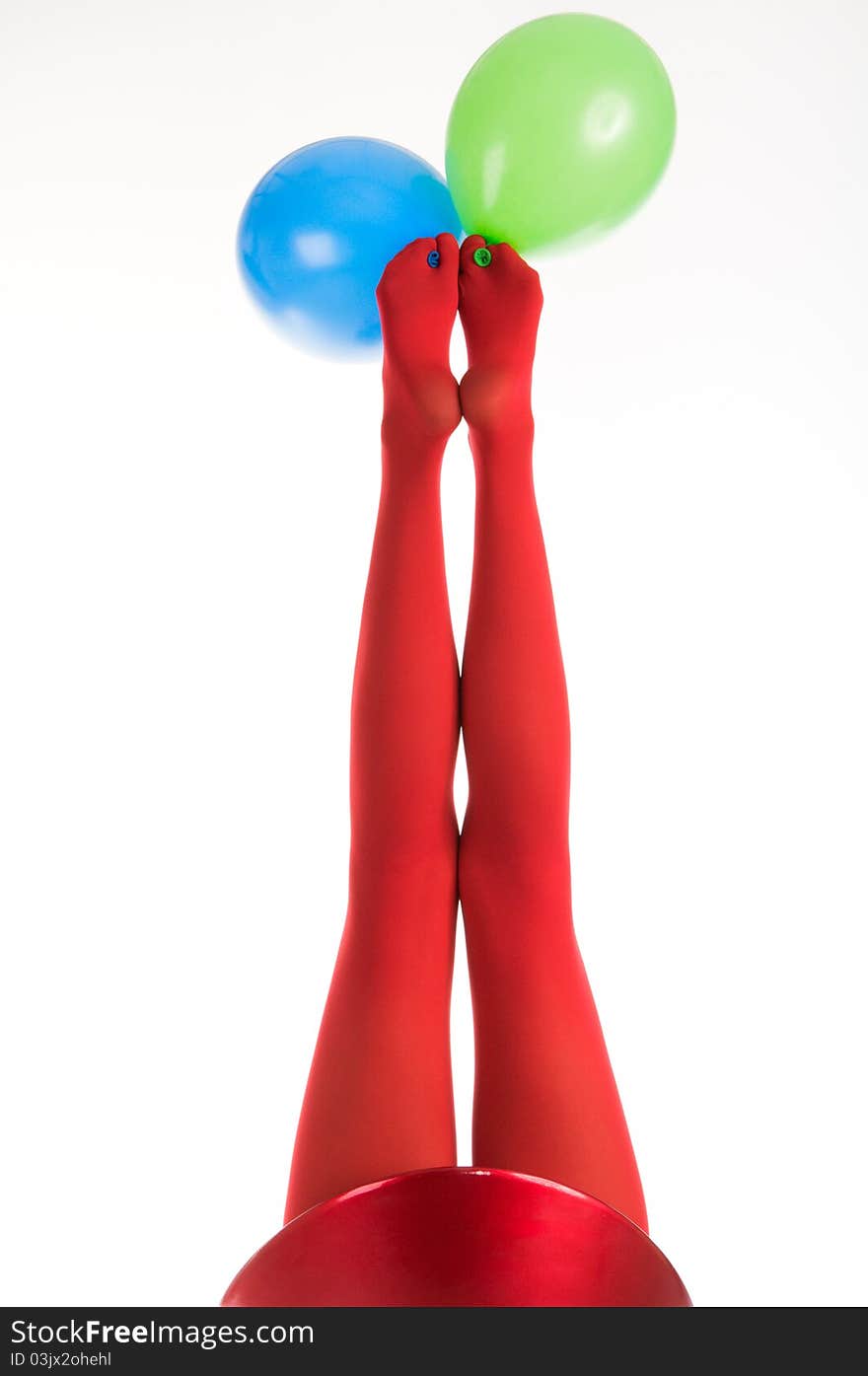 Female feet in red stockings with balloons isolated in white