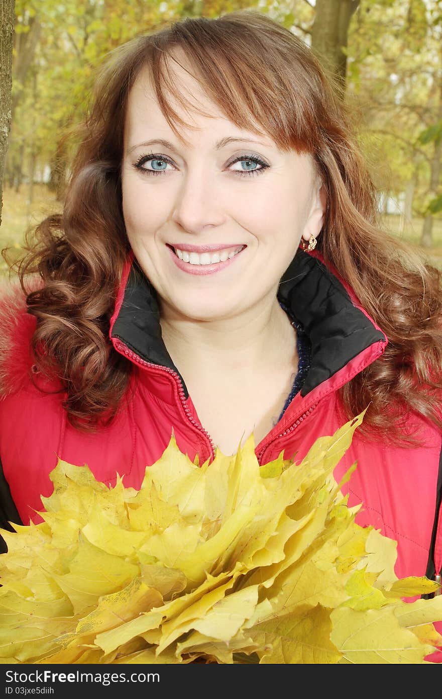 Happy woman in autumn holds the bouquet of leaves