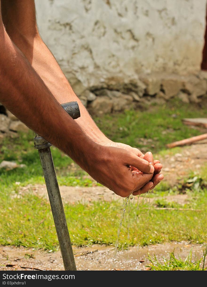 Closeup of hands washing in water form a broken pipe. Closeup of hands washing in water form a broken pipe