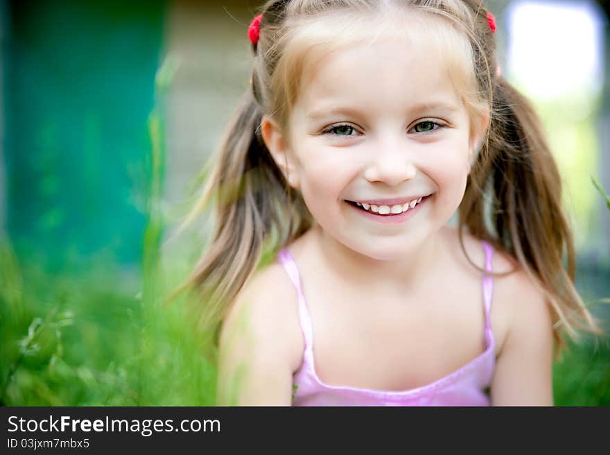 Cute little girl smiling in a park close-up