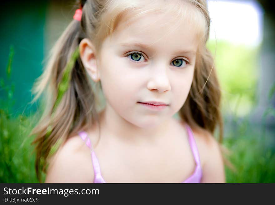 Cute little girl smiling in a park close-up