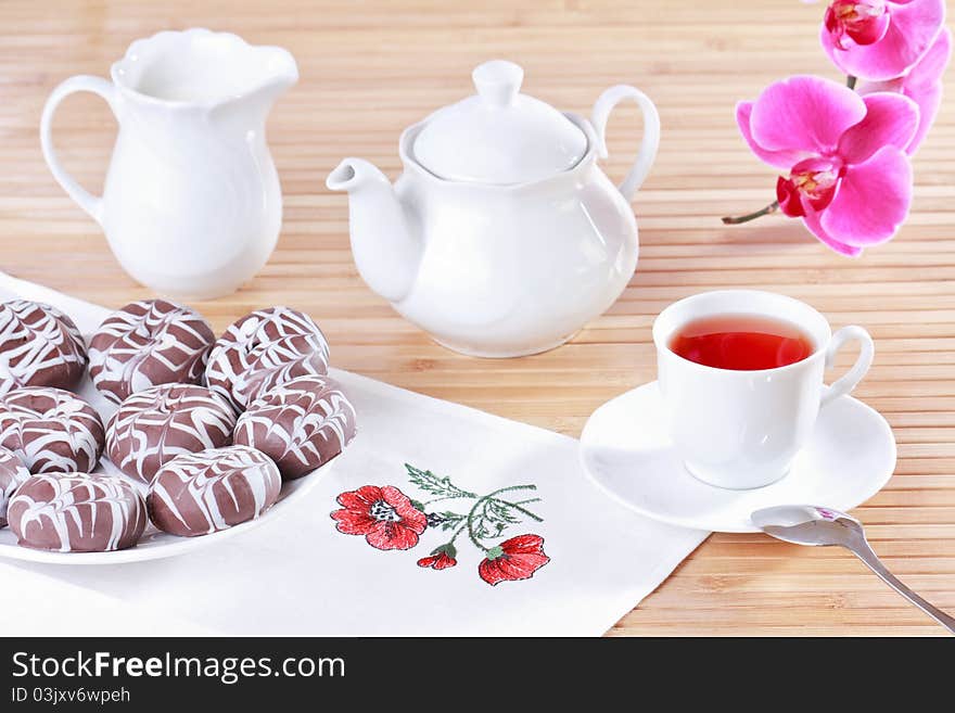 Cup of tea, teapot and chocolate iced spice cakes