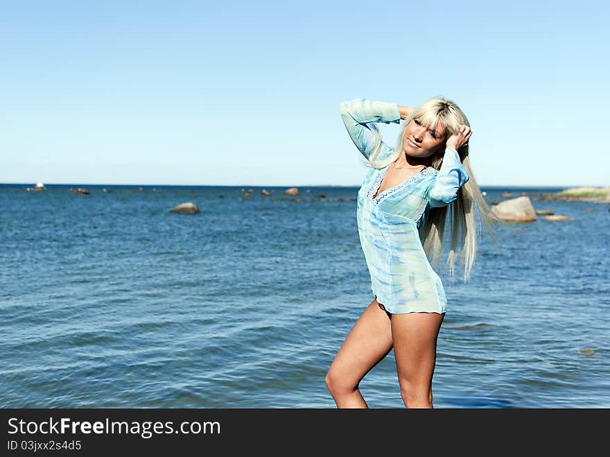 Girl in a blue tunic is enjoying summer on the beach. Girl in a blue tunic is enjoying summer on the beach