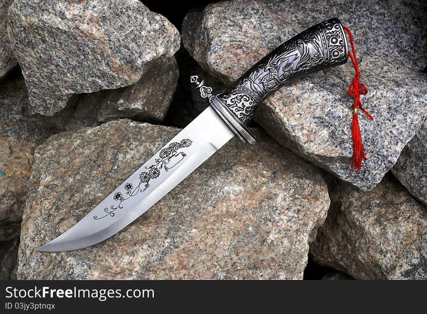 The big hunting knife on granite stones. The big hunting knife on granite stones.