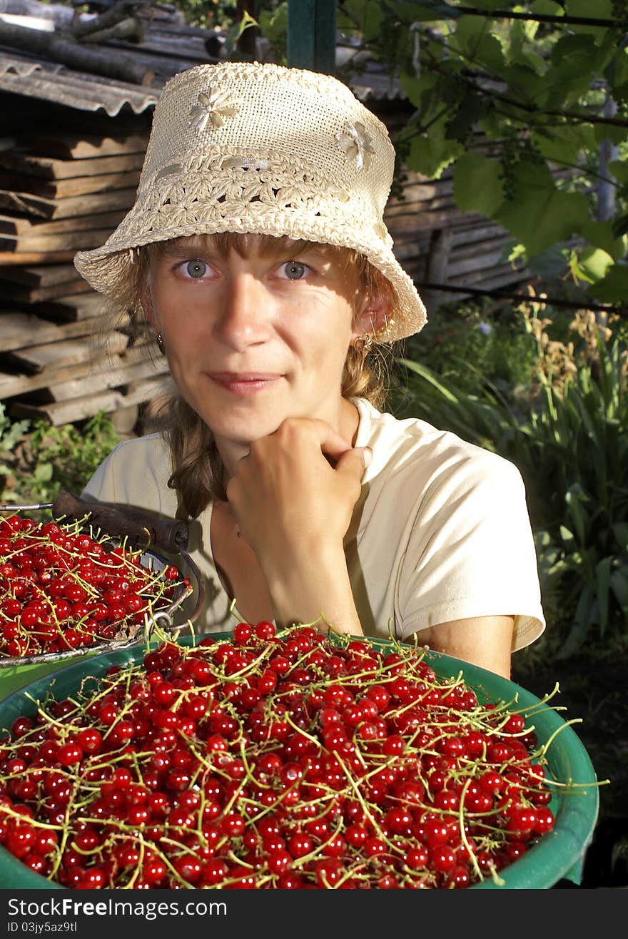 The young woman sells a red currant in the marcet. The young woman sells a red currant in the marcet.