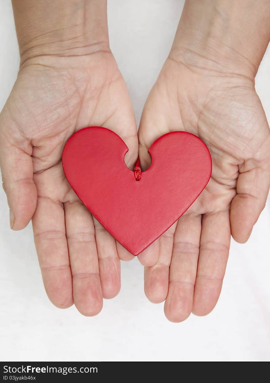 Two female hands offering a loving heart. Two female hands offering a loving heart.