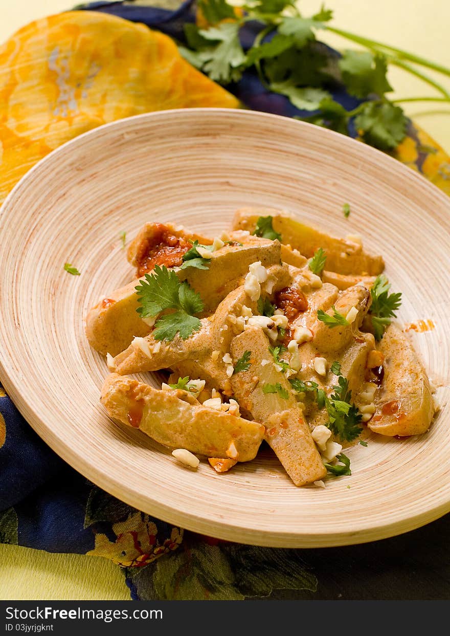 Bowl of spicy curry with vegetables and nut. Selective focus; shallow depth of field.