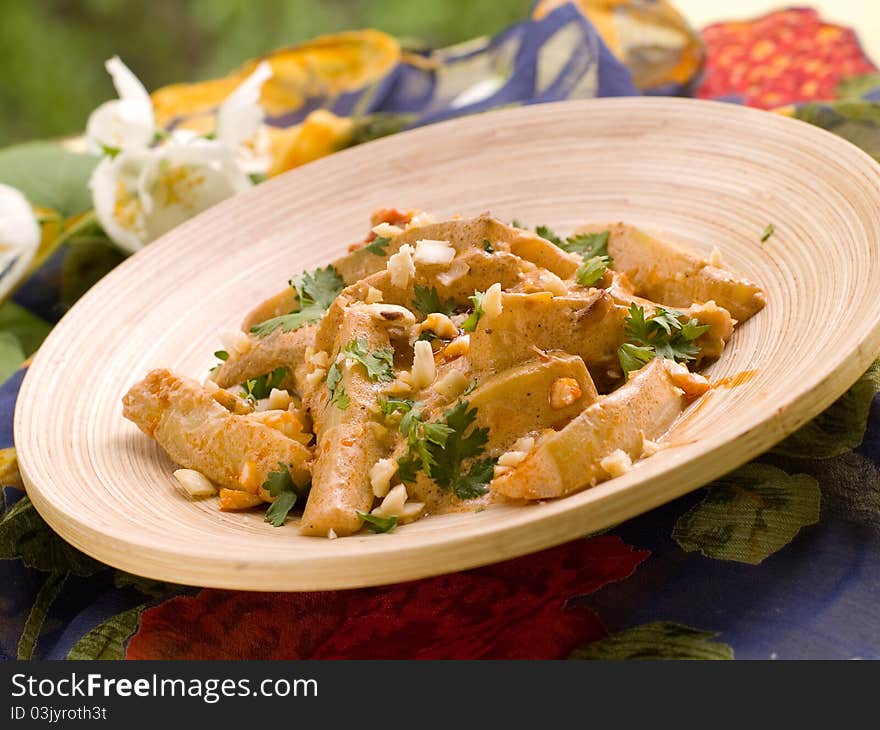 Bowl of spicy curry with vegetables and nut. Selective focus; shallow depth of field.