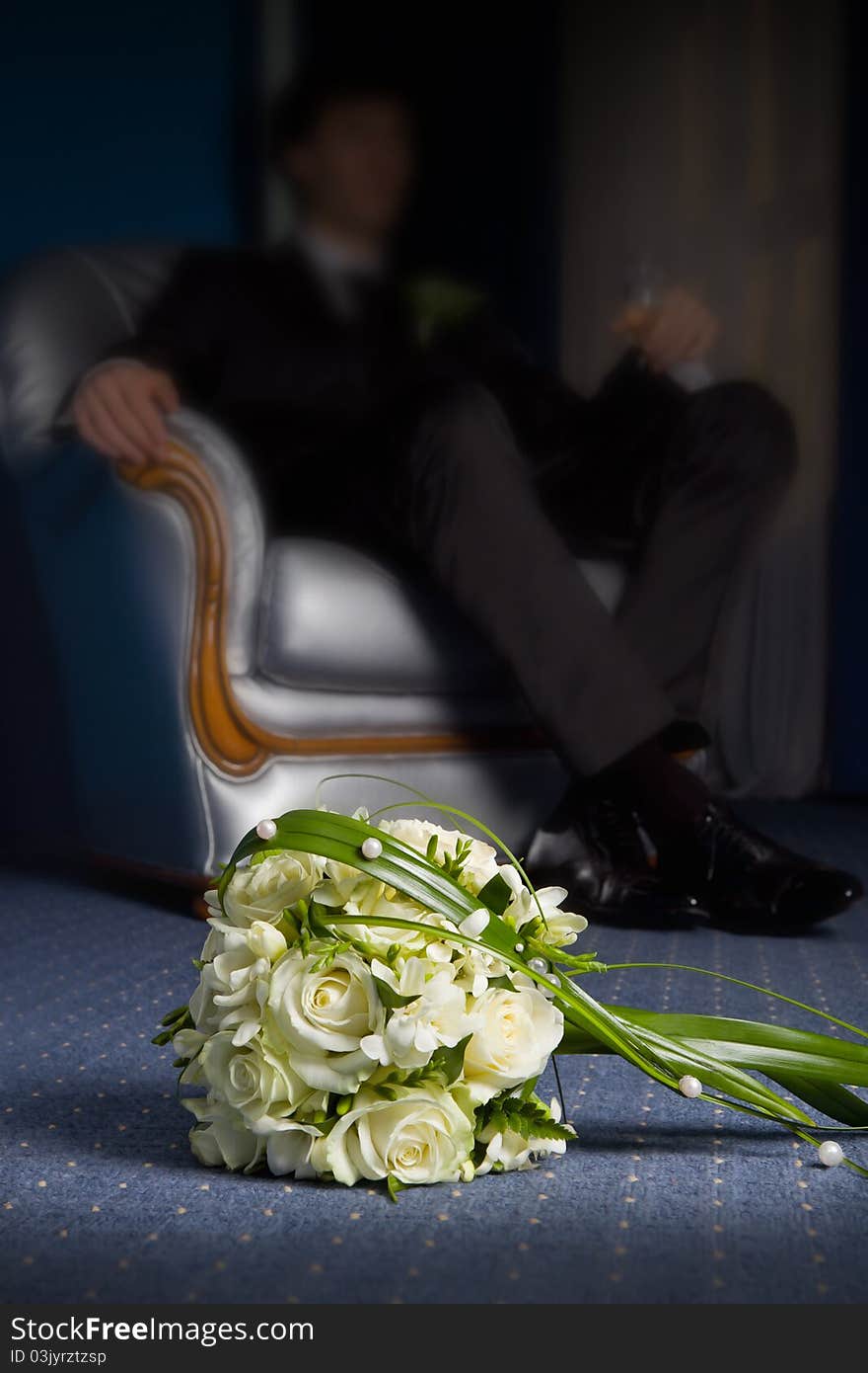 Wedding bouquet with the groom in the background