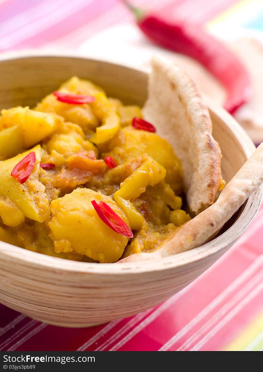 Bowl of spicy curry with potato and chilly Selective focus; shallow depth of field.