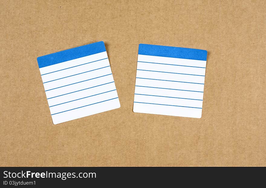 Tags white and blue on corrugated cardboard. Tags white and blue on corrugated cardboard