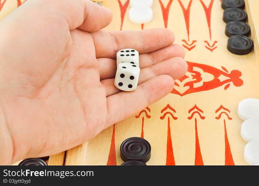 Hand with dices and backgammon