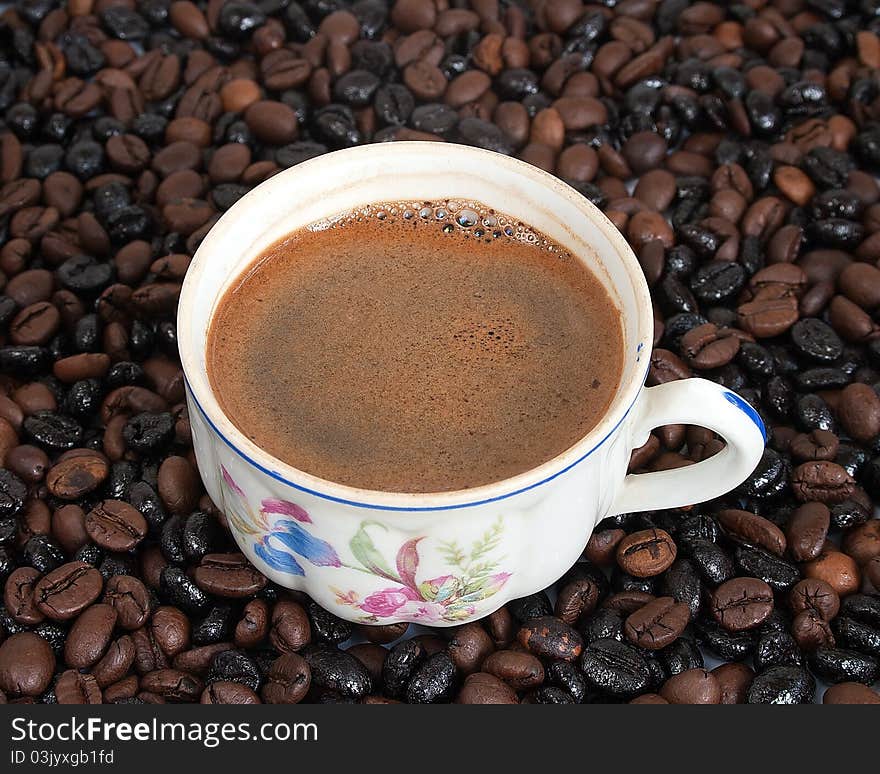 The cup of coffee on coffee-beans background