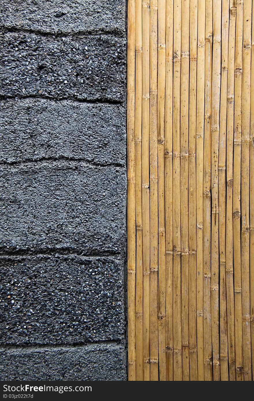 Vertical line of bamboo and horizontal grooved line on rustic concrete wall. Vertical line of bamboo and horizontal grooved line on rustic concrete wall